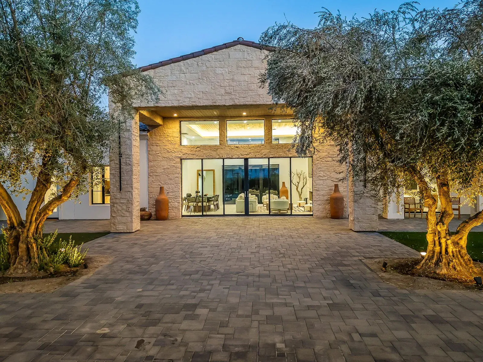 The villa and its olive court in afternoon light